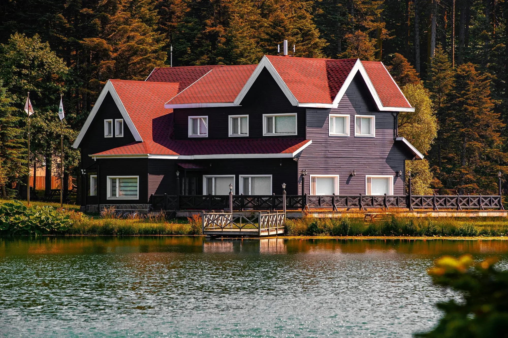 Statement home on a wooded lakefront at dusk